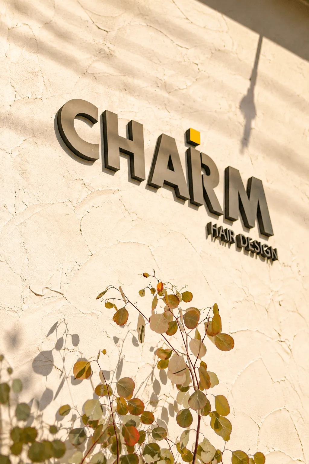 暖かな陽光が差すCHARM HAIR DESIGNの看板